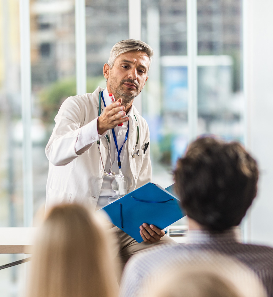 Doctor presenting to a crowd of medical professionals about tissue banking practices.